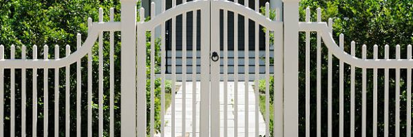 Front gate and white fence on elegant house entrance